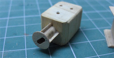 Le moteur : un bloc de bois (les trois trous seront garnis d’un morceau de tube laiton sur lequel seront fixs des scoubidous), et l’axe du moteur dont le trou va recevoir le systme d’attache du crochet. - 12.9 ko